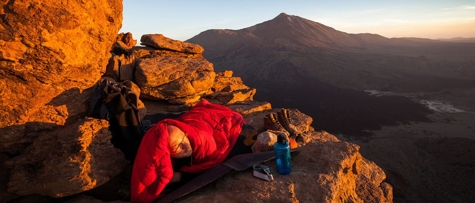 im schlafsack bei sonnenaufgang im gebirge andre schumacher